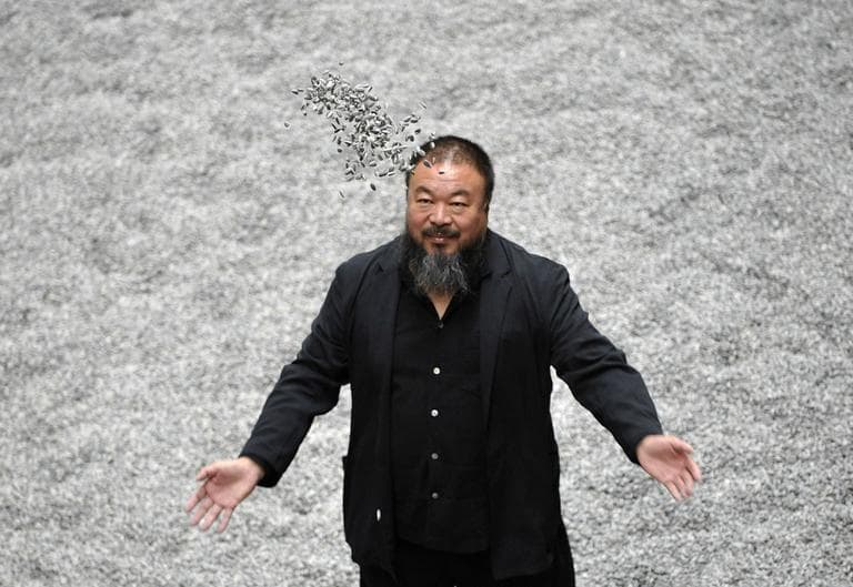 Chinese artist Ai Weiwei poses with some seeds from his art installation 'Sunflower Seeds' in London in 2010. (AP)