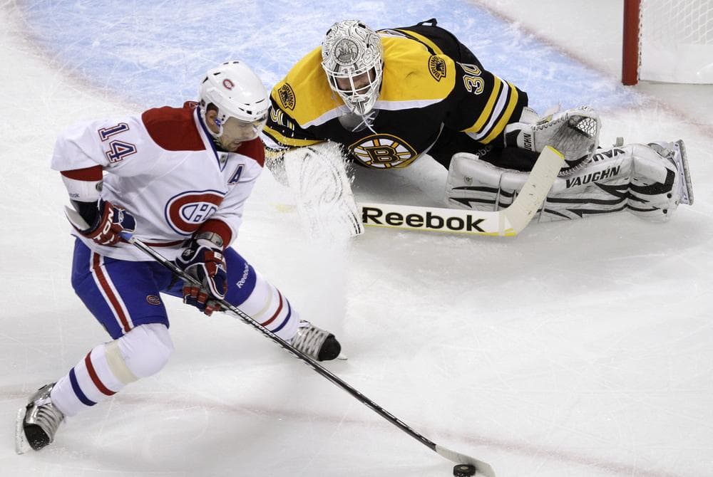 Boston Bruins goalie Tim Thomas, top, drops to the ice to make a save on a shot by Montreal Canadiens center Tomas Plekanec during the playoff game in Boston on Thursday. (AP)