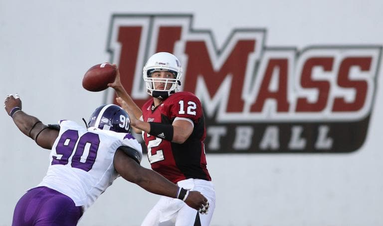 Massachusetts quarterback Kyle Havens looks to pass as Holy Cross defender Mude Ohimor closes in during an NCAA college football game in Amherst, Mass. in September. (AP)