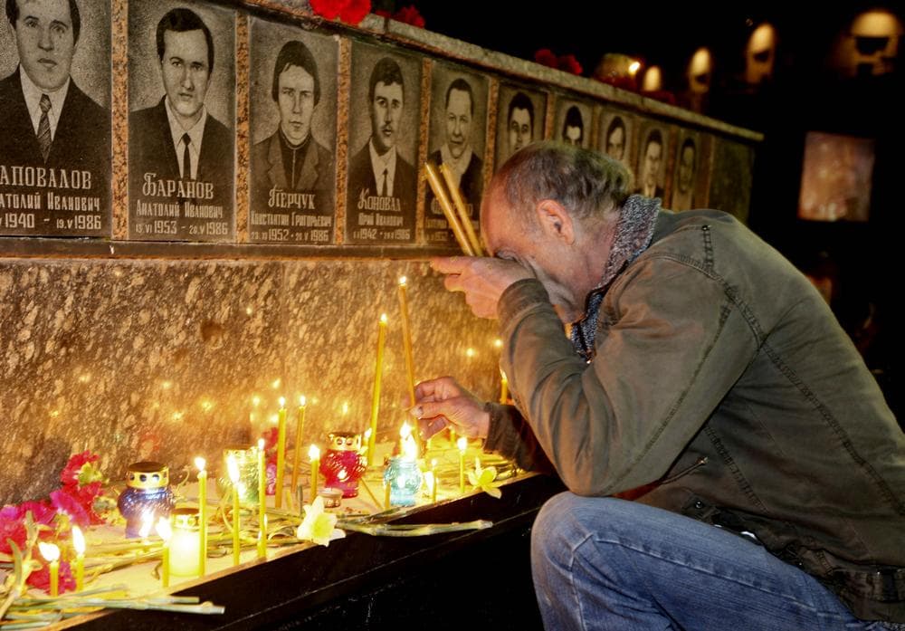 A Ukrainian lights candles to commemorate those who died after the Chernobyl nuclear disaster in Slavutich on Tuesday. (AP)