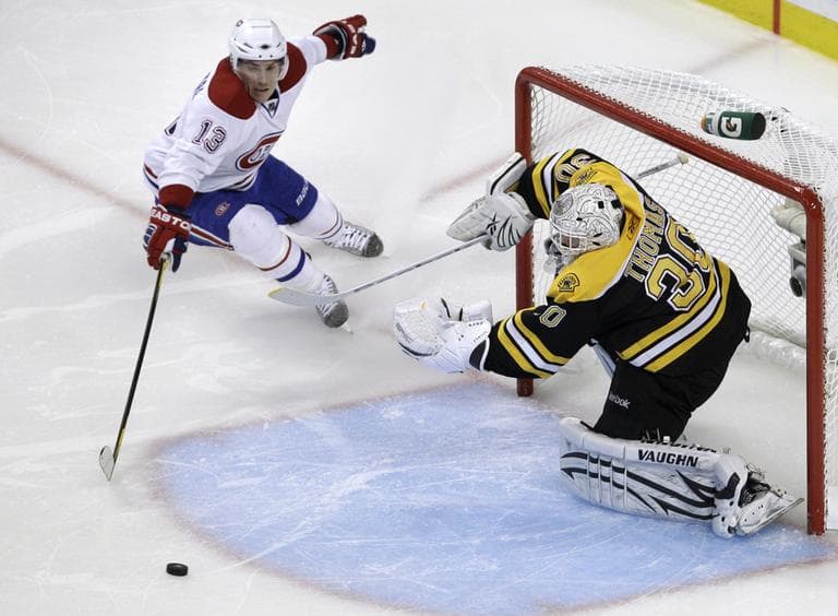 Bruins goalie Tim Thomas clears the puck away after a save as Montreal Canadiens left wing Michael Cammalleri tries to gain possession. (AP)