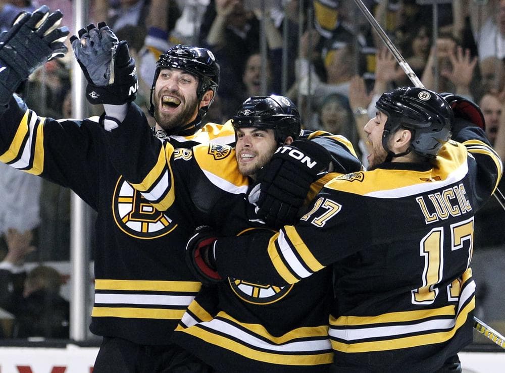 Zdeno Chara, left, and Milan Lucic, right, celebrate with Nathan Horton after he scored the game-winning goal against the Montreal Canadiens in Game 7 Wednesday.  (AP)