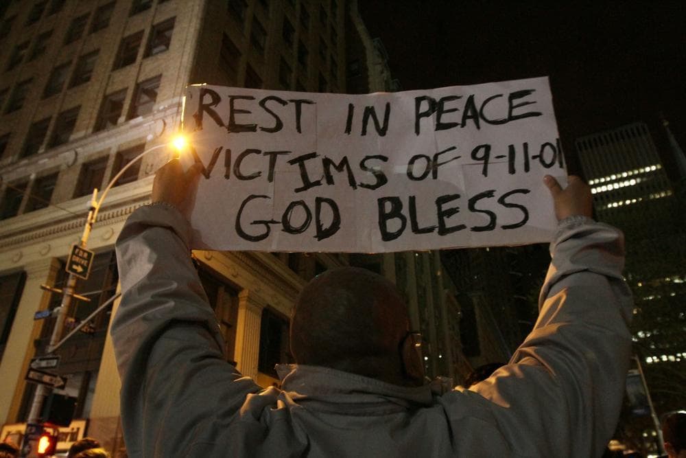 Herman Maisonave, of the Queens borough of New York, holds up a sign as he joins those gathered by ground zero in New York early Monday morning. (AP)