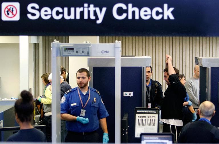 Passengers pass through security, including a full-body scanner, at Logan International Airport on Nov. 24, 2010. (AP)