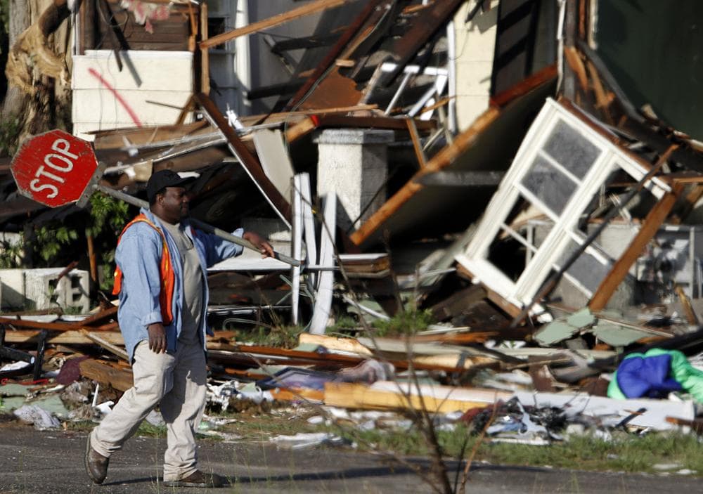 A flagman walks down a street as workers begin to remove debris from areas hard hit when a tornado ripped through McDonald's Chapel last Wednesday in McDonald's Chapel, Ala. (AP)