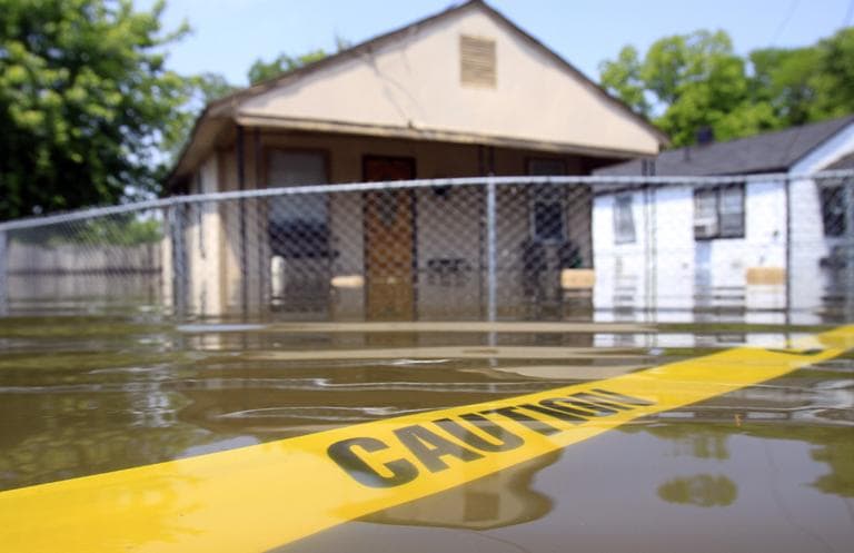 Caution tape floats in floodwater surrounding a home in Memphis, Tenn. (AP)