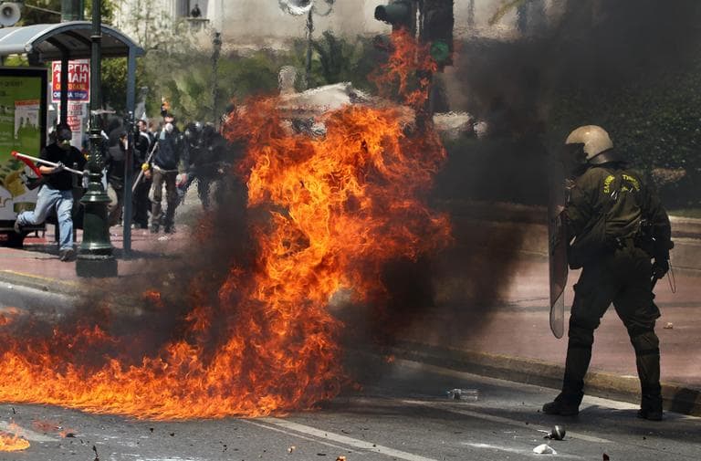 A Petrol bomb explodes next to a riot policeman during a mass demonstration in central Athens as a general strike in the crisis-hit country halted services and disrupted flights, Wednesday. (AP)