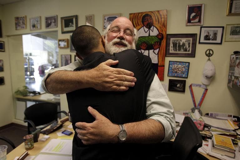 Father Gregory Boyle hugs Robert Trejo, a former gang member, in his office at Homeboy Industries in Los Angeles. (AP)