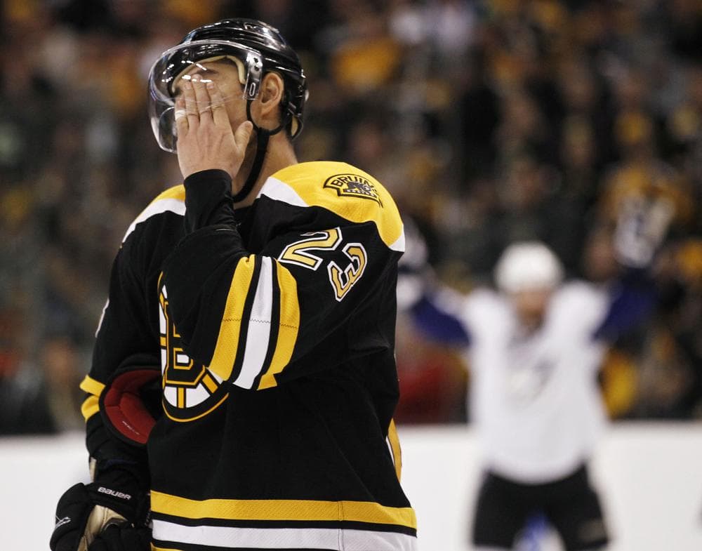 Bruins&#039; Chris Kelly wipes his face as a Tampa Bay Lightning player celebrates a goal during the third period of Game 1 of an NHL hockey Stanley Cup Eastern Conference final playoff series, Saturday, May 14, 2011, in Boston. (AP Photo/Winslow Townson)
