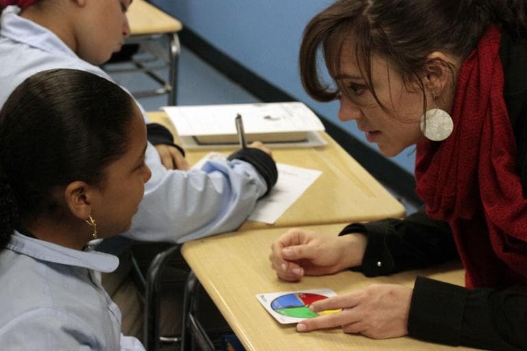 Roxbury Prep teacher Mara Radriguez works with a student in her classroom (Jesse Costa/WBUR)