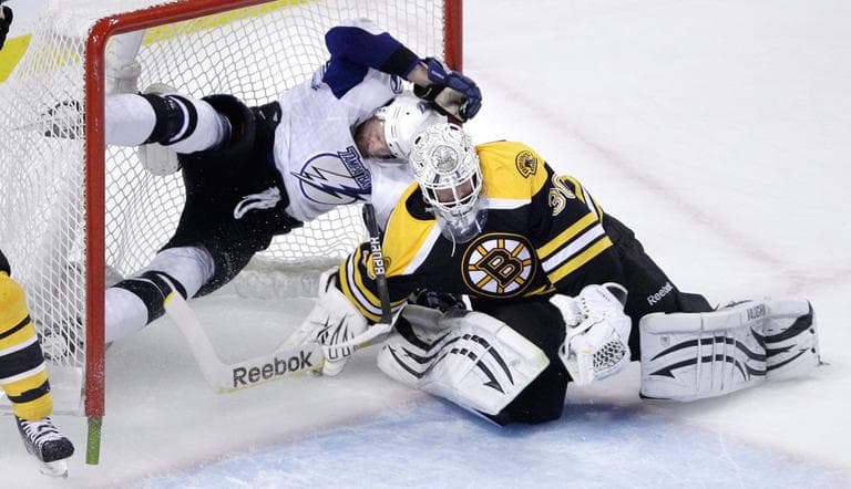 Boston Bruins goalie Tim Thomas makes a save as Tampa Bay Lightning center Steven Stamkos ends up airborne as he is checked into the goal during Game 5 of the Eastern Conference finals in Boston on Monday. (AP)