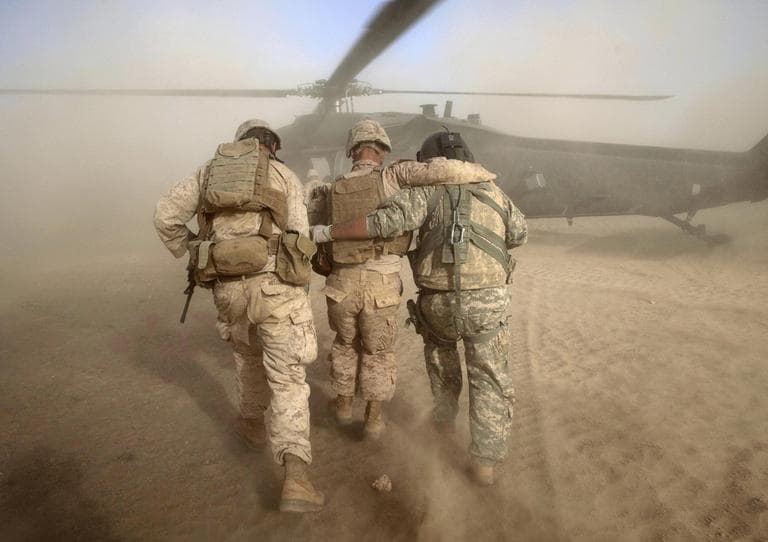 US Army flight medic SGT Jaime Adame, right, and an unidentified United States Marine help Marine LCPL Chris Propst of South Carolina, center, who was wounded in an insurgent attack in Afghanistan, May 15. (AP)