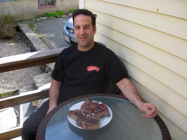 B.good chef Tony Rosenfeld with grilled pork chops on his back porch in Marblehead. (Adam Ragusea/WBUR)