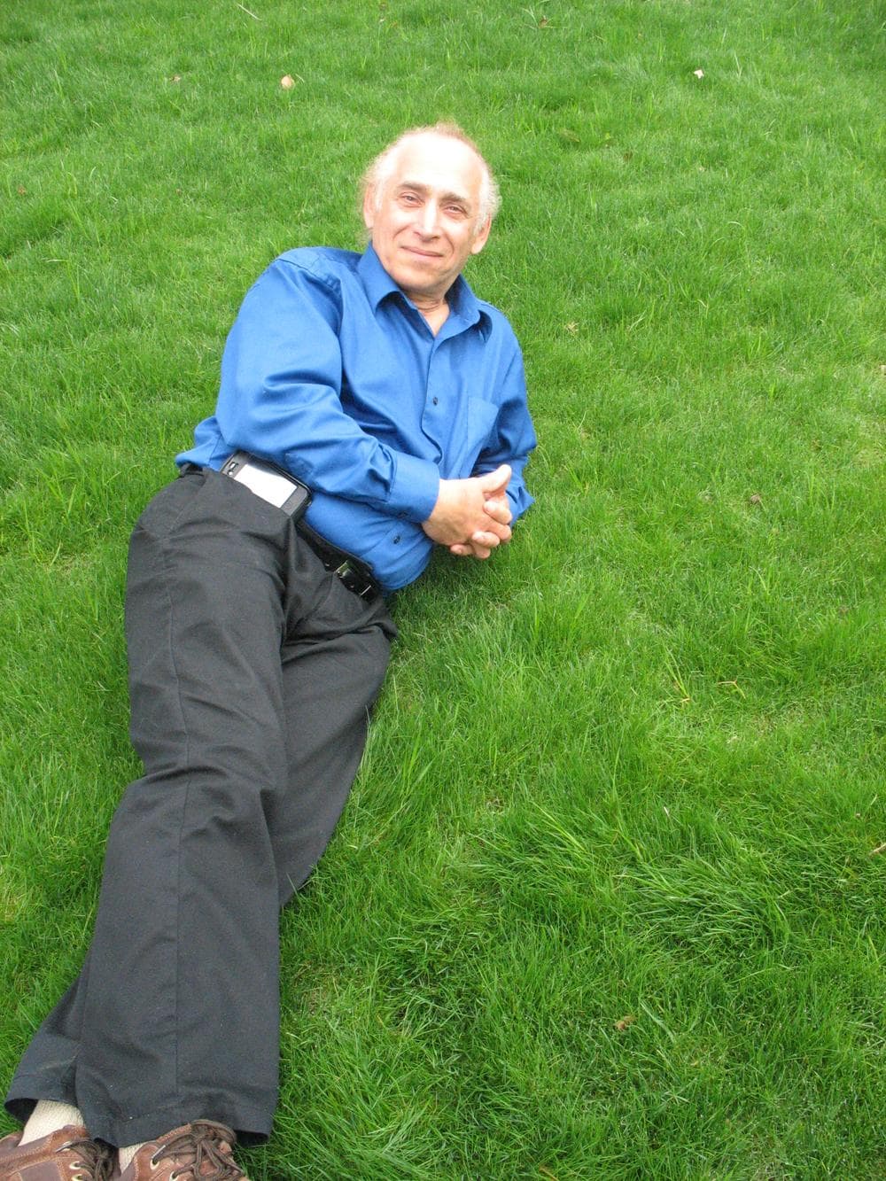 Jackson Madnick, the investor of Pearls Premium grass seed, lies down on lawn seeded with his ultra low maintainence grass. (Photo by Monica Brady-Myerov)
