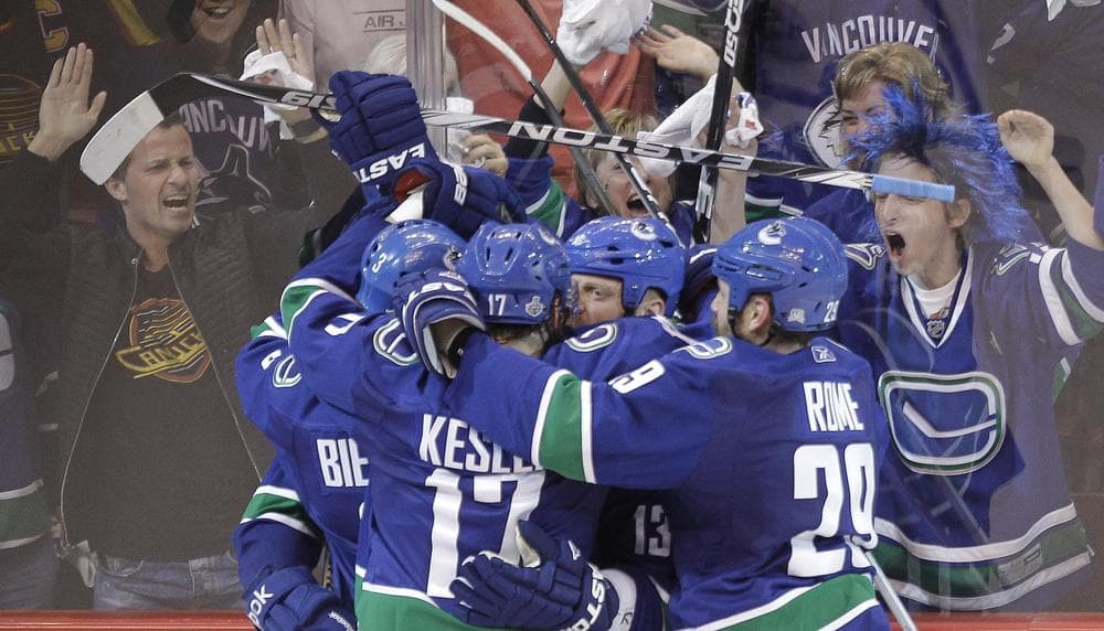 The Vancouver Canucks celebrate after scoring the game winning goal in Game 1 of the Stanley Cup Finals Wednesday in Vancouver. (AP)