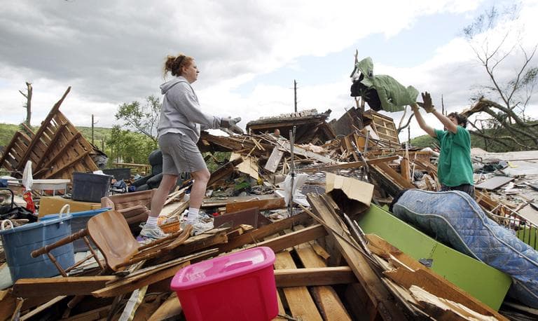 Joe Yarbrough, 12, tosses a jacket to his mom, Laura, as they salvage belongings from their home. (AP)
