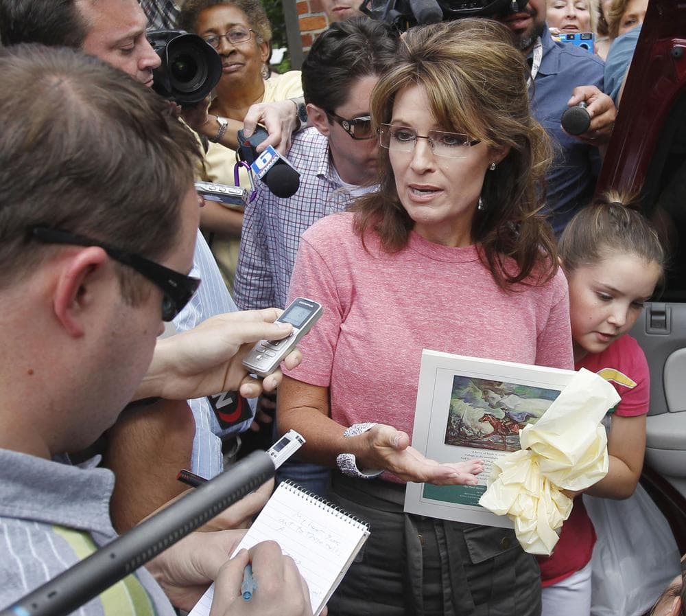 Former Alaska Gov. Sarah Palin, holds a booklet depicting Paul Revere, while she speaks with the media as she tours Boston's North End neighborhood on June 2. (AP)