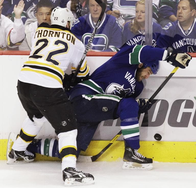 Boston Bruins right wing Shawn Thornton (22) and Vancouver Canucks left wing Tanner Glass (15) battle up against the boards during Game 5 on Friday in Vancouver, B.C. (AP)