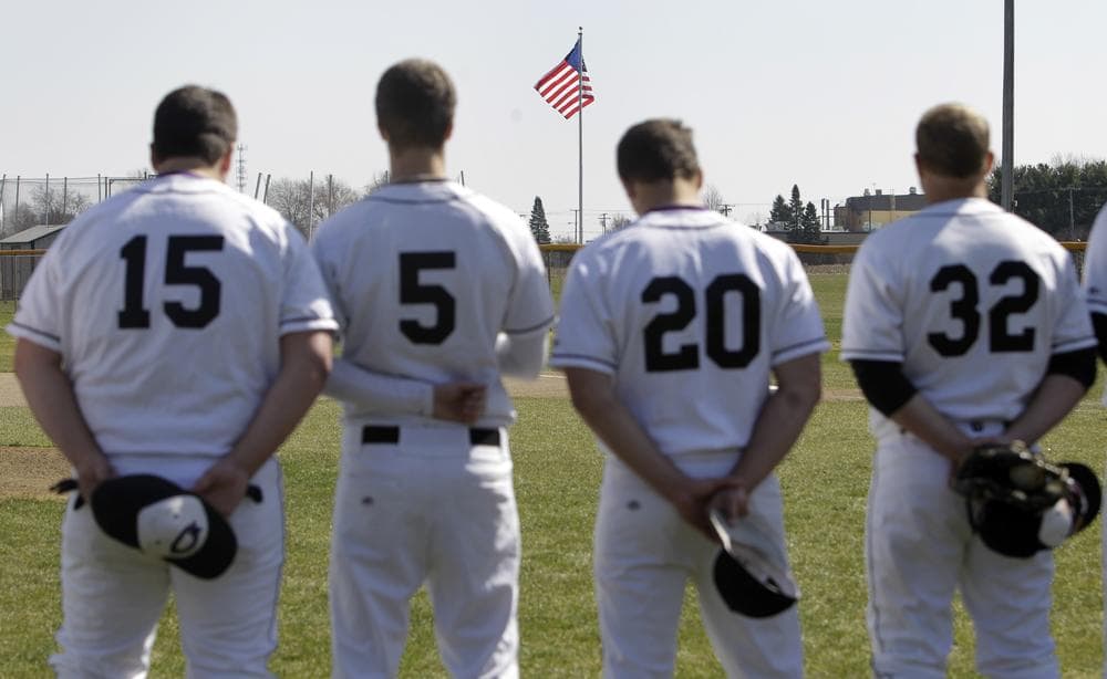 Goshen College baseball team members, left to right, Caleb Yoder, Lance Good, Clay Norris and Andy Swisher stand along the third base line for the singing of the national anthem in Goshen, Ind., Tuesday, March 23, 2010.  The national anthem was played before the game against Sienna Heights for the first time at the Mennonite-affiliated school. (AP)