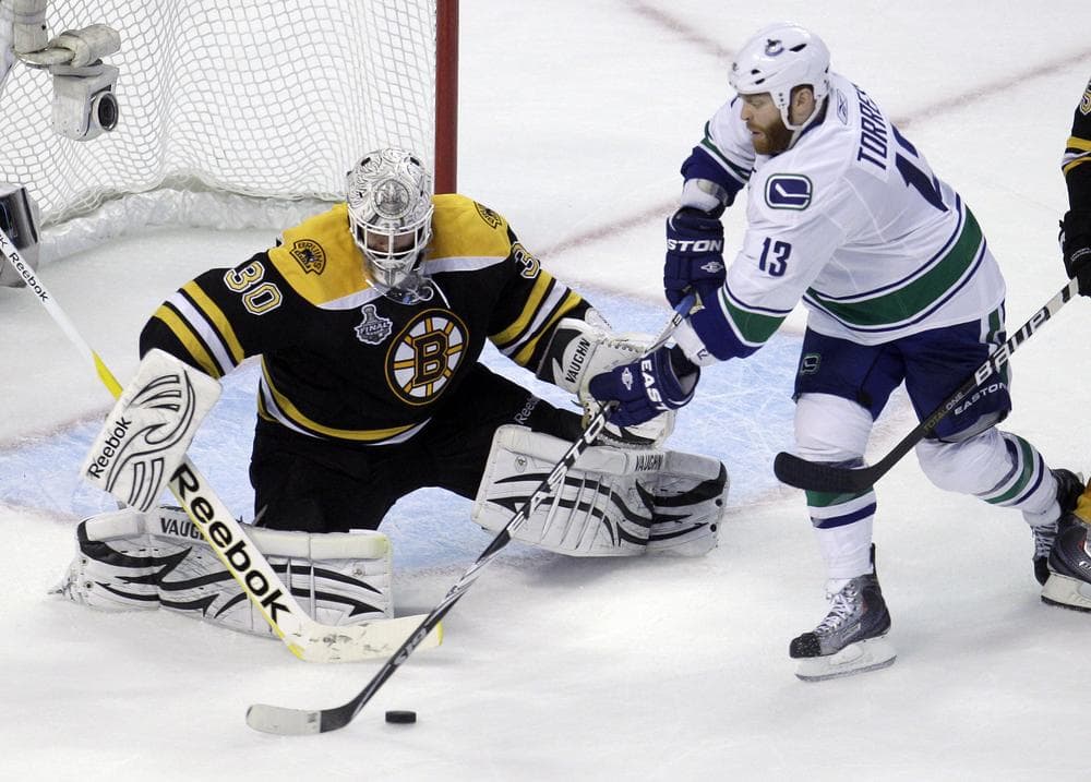 Boston Bruins goalie Tim Thomas, left, makes a save against Vancouver Canucks left wing Raffi Torres (13) during the third period in Game 6 of the NHL hockey Stanley Cup Finals in Boston, Monday. (AP)