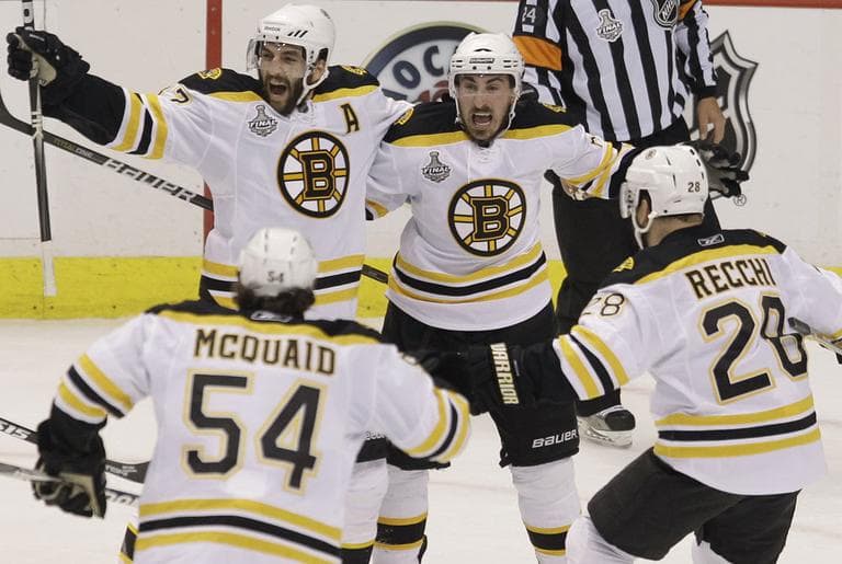Bruins Patrice Bergeron (37), Brad Marchand (63), Adam McQuaid (54) and Mark Recchi (28) celebrate after a first-period goal by Bergeron Wednesday. (AP)