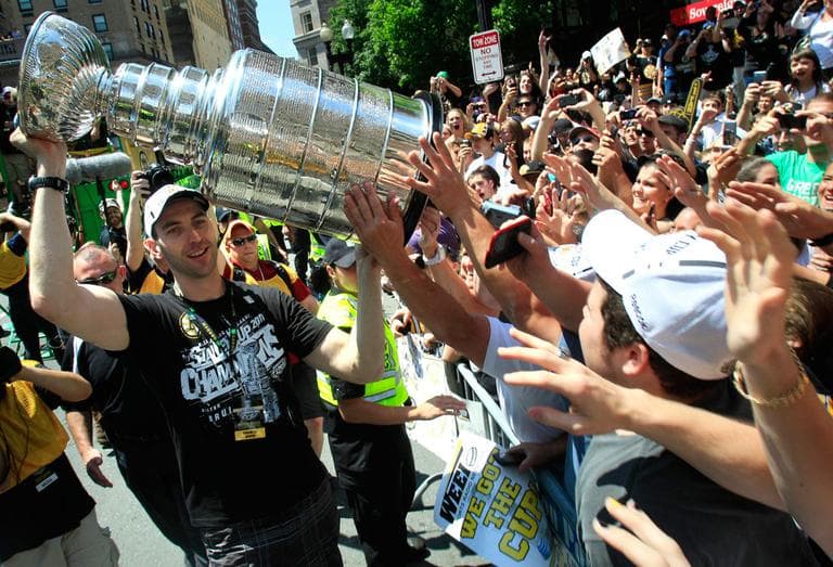 Bruins captain Zdeno Chara briefly left his duck boat to give fans a close look at the Stanley Cup during the victory parade Saturday. (AP)