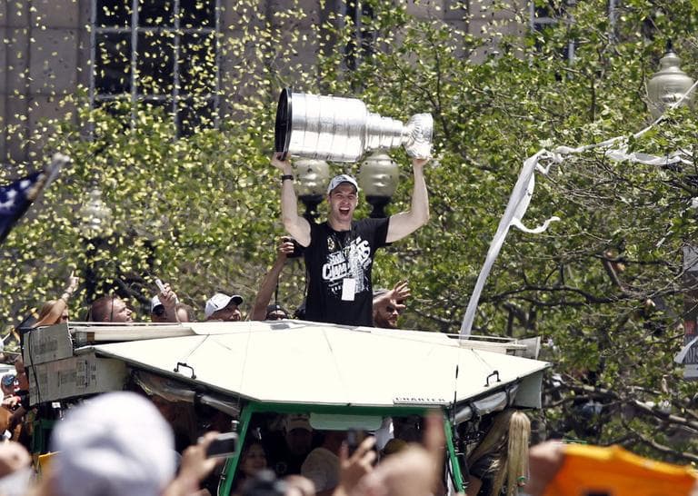 Boston Bruins captain Zdeno Chara raises the Stanley Cup during a parade through the streets of Boston on June 18. (AP)