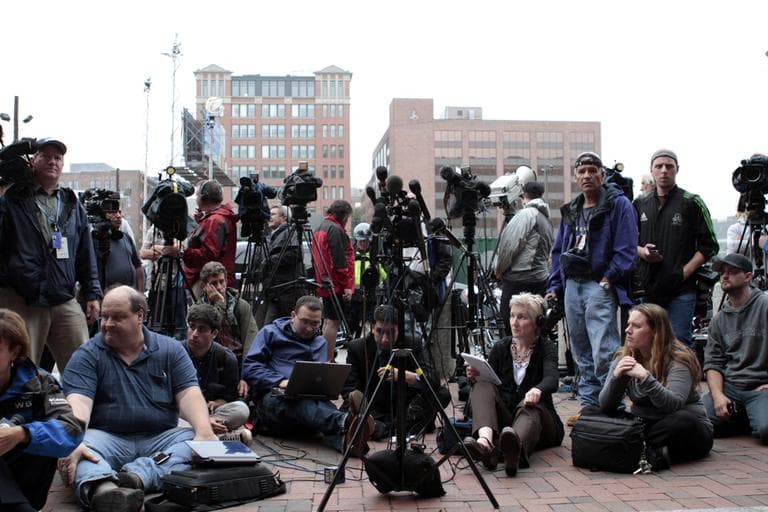Reporters await &quot;Whitey&quot; Bulger's arrival outside the federal courthouse in Boston on Friday. WBUR's Martha Bebinger is seated with headphones (Jesse Costa/WBUR)   