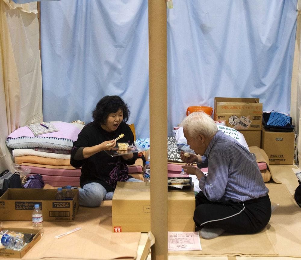 A Japanese refugee couple eat their dinner in their allotted space at an arena used as evacuation center in Koriyama, Fukushima prefecture, northeastern Japan in late May. (AP)