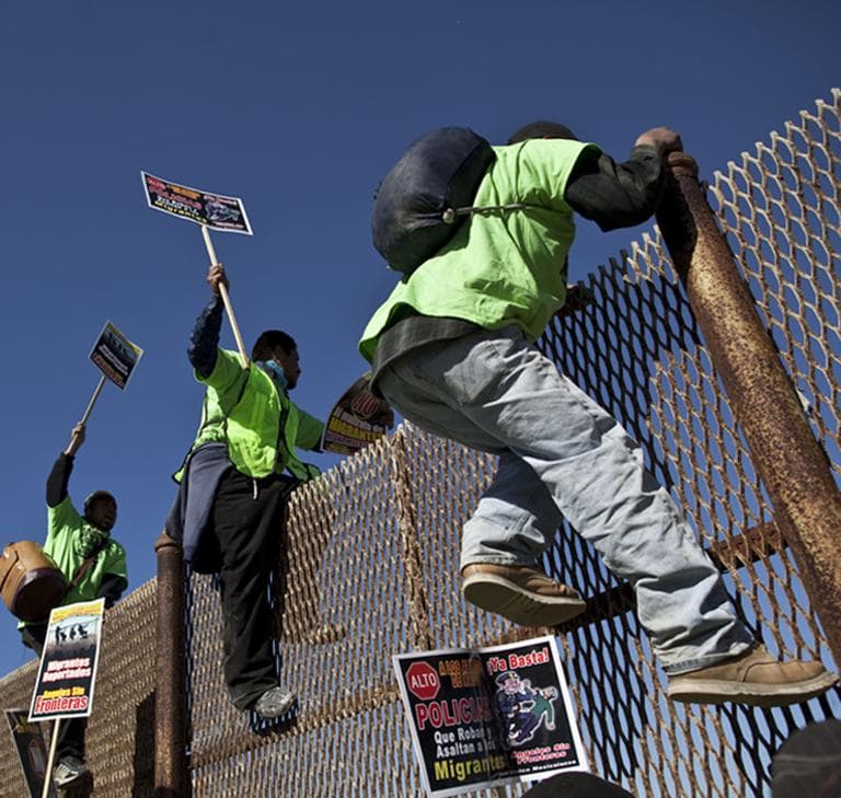 Deported migrants climb a fence at the U.S.- Mexico border as they prepare for the 6th annual Marcha Migrante, or Migrant March in Tijuana, a pilgrimage is organized to raise awareness on immigration issues. (AP)