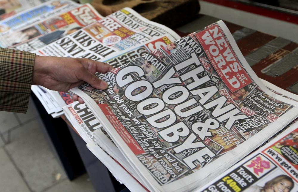 A customer buys a copy of News of the World from a newspaper vendor in central London, Sunday. (AP)