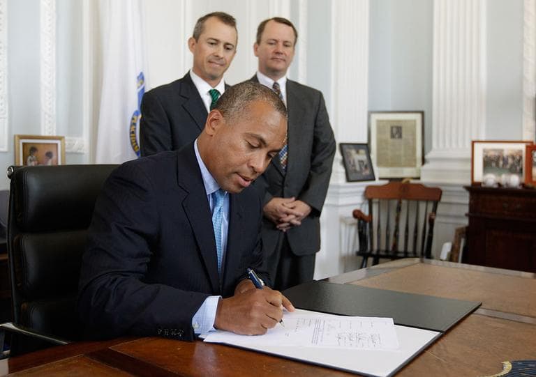 Gov. Deval Patrick signs the 2012 fiscal year budget in his office Monday. Looking on are Lt. Gov. Timothy Murray, right, and Secretary of Administration and Finance Jay Gonzalez. (AP)