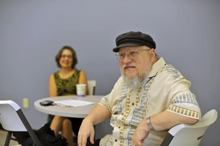 George R. R. Martin chats with employees from WBUR in the staff kitchen before heading into the studio and talking with Tom Ashbrook. (Alex Kingsbury / WBUR)