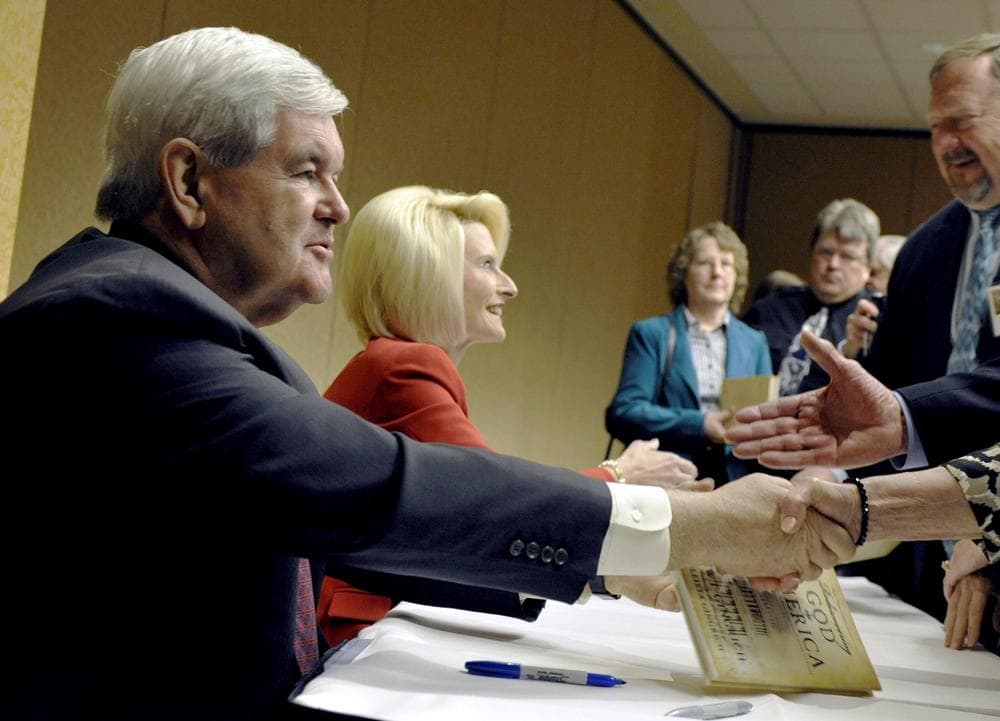 Republican presidential candidate Newt Gingrich and his wife Callista sign their book, &quot;Rediscovering God in America&quot; in Minnesota. (AP)