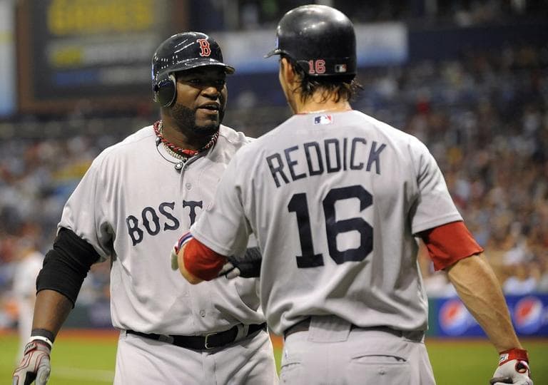 David Ortiz celebrates with teammate Josh Reddick after scoring off J.D. Drew's double during a game against the Rays Saturday. (AP)