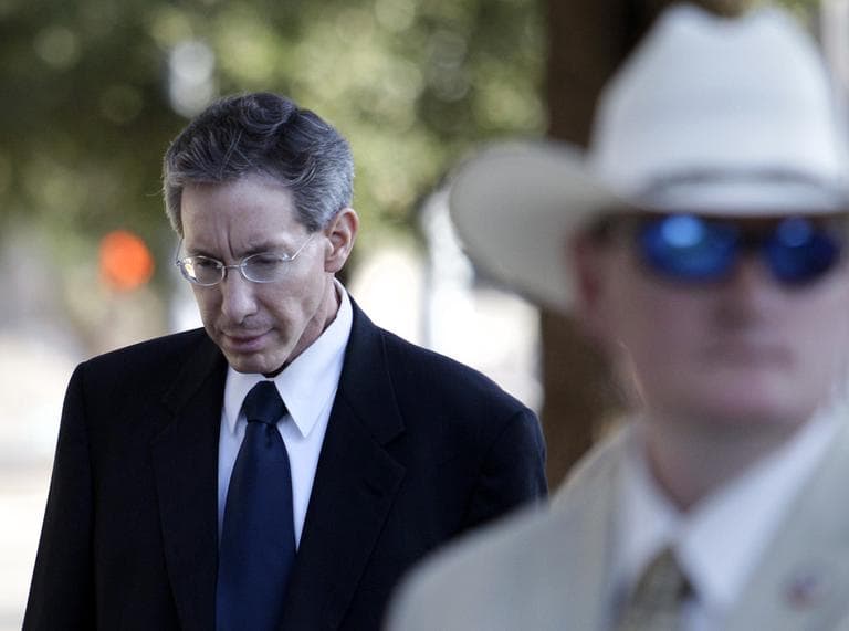 A law enforcement official stands by as Polygamist sect leader Warren Jeffs, left, arrives in court, Thursday, in San Angelo, Texas. (AP)