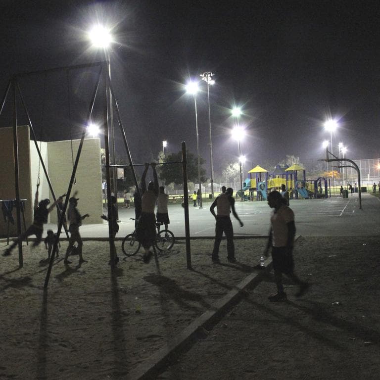 Residents hang out at the basketball court at Algin Sutton Recreation Center in South Los Angeles. The center is being included in the city's Summer Night Lights program to reduce gang violence. (AP)