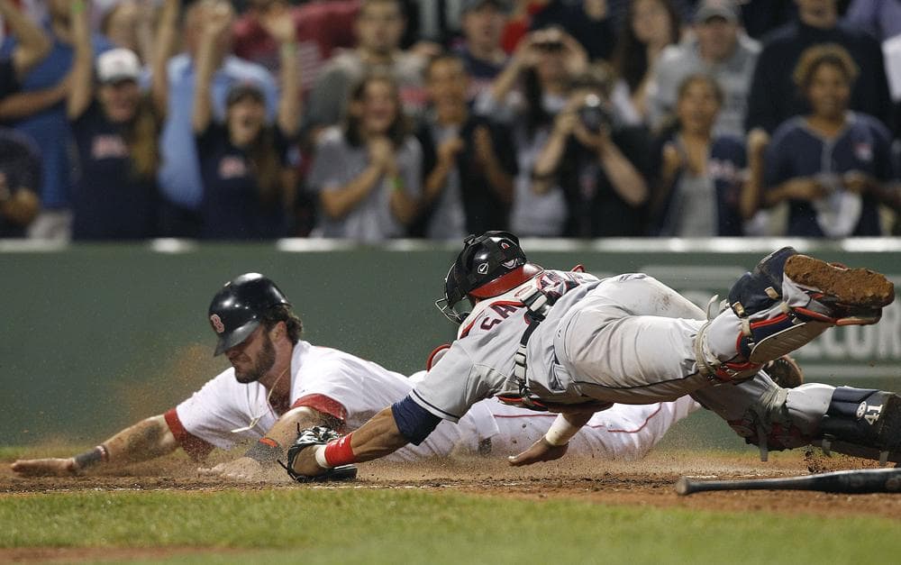 Boston Red Sox&#39;s Jarrod Saltalamacchia dives for home plate to score the winning run as Cleveland Indians catcher Carlos Santana tries to tag him in the ninth inning Tuesday. The Red Sox won 3-2. (AP)