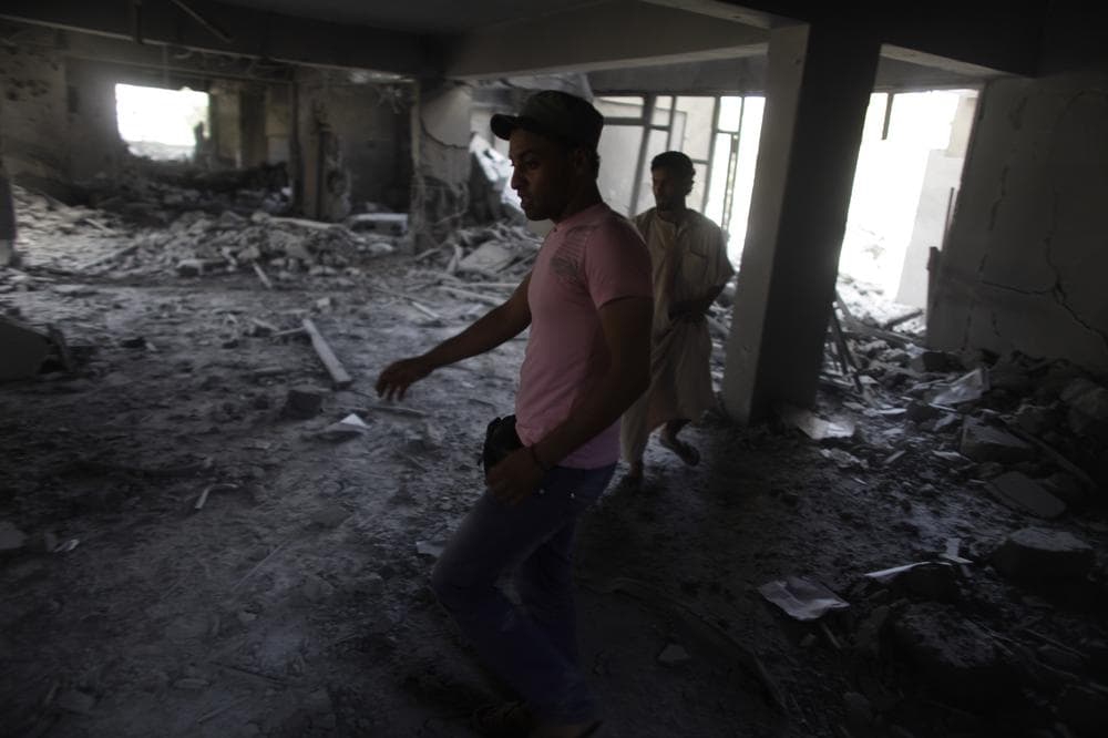 In this photo taken on a government-organized tour men stand inside the rubble of the law school building in Zliten, Libya, Thursday. In recent weeks Libya's rebels have been slowly advancing on Zliten aided by NATO airstrikes. (AP)