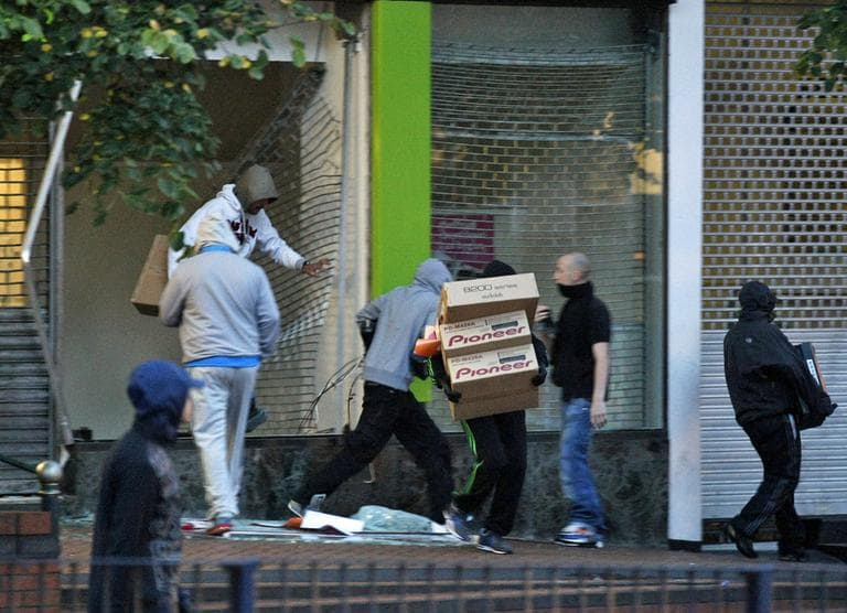 Looters take electrical goods after breaking into a store during the second night of civil disturbances in central Birmingham, England, Tuesday, Aug. 9, 2011. (AP)