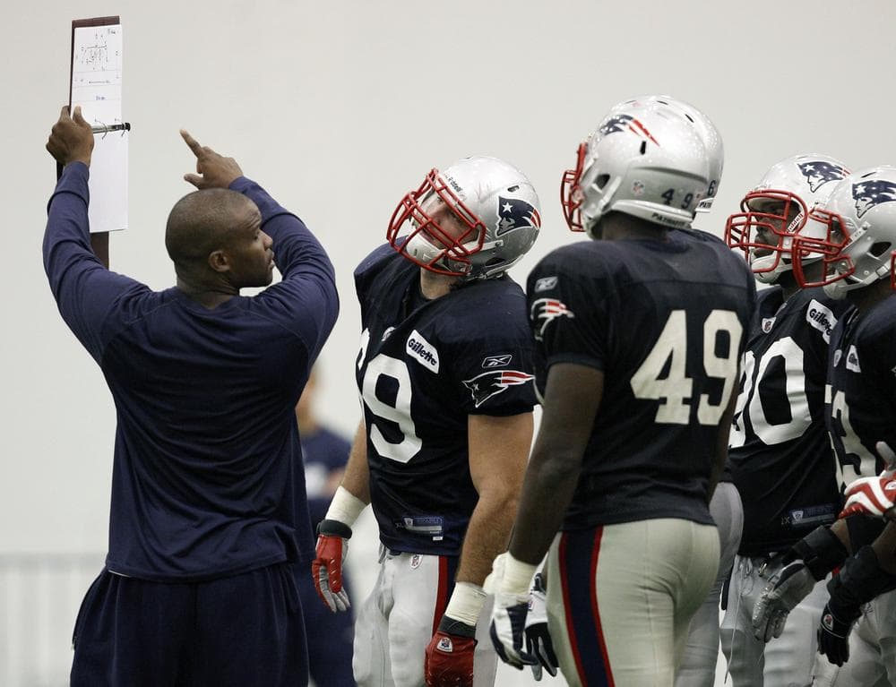 New England Patriots defensive assistant coach Brian Flores goes over a play during NFL football training camp in Foxborough, Mass. on Monday. (AP)