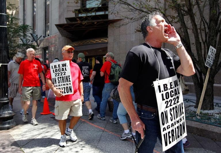 Verizon worker Steven Simard, right, of Danvers, pickets outside a Verizon office in Boston on Aug. 12. (AP)