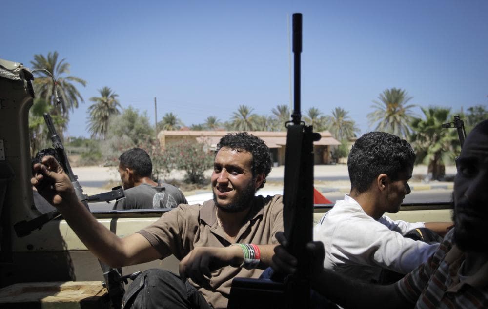 Rebel fighters drive toward the frontline in the village of Mayah, some 30 kilometers west of Tripoli, Sunday. (AP)