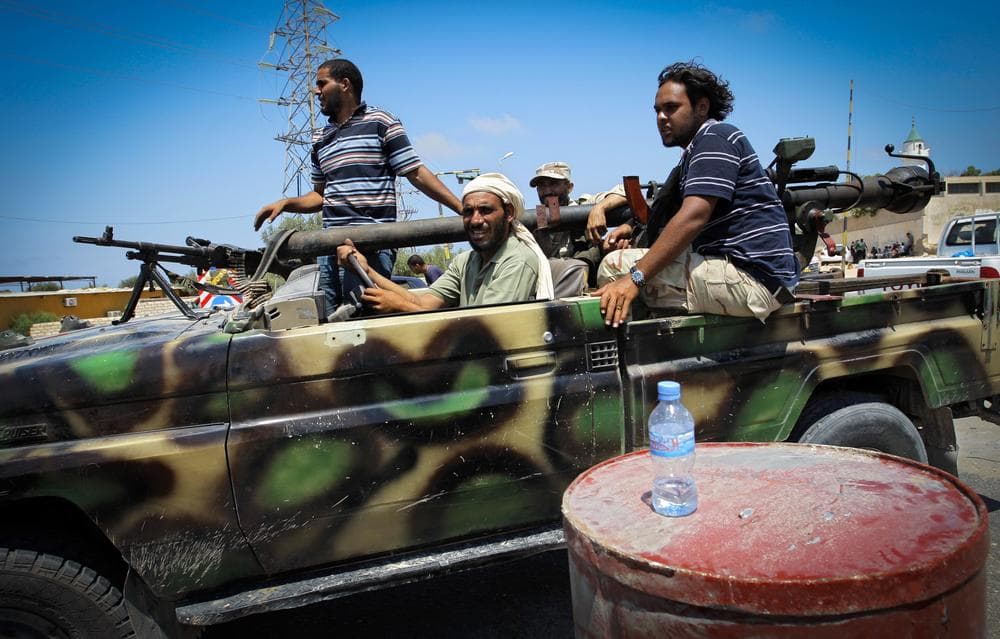 Rebel fighters speed toward frontllne fighting in the village of Mayah, west from Tripoli, Sunday. (AP)
