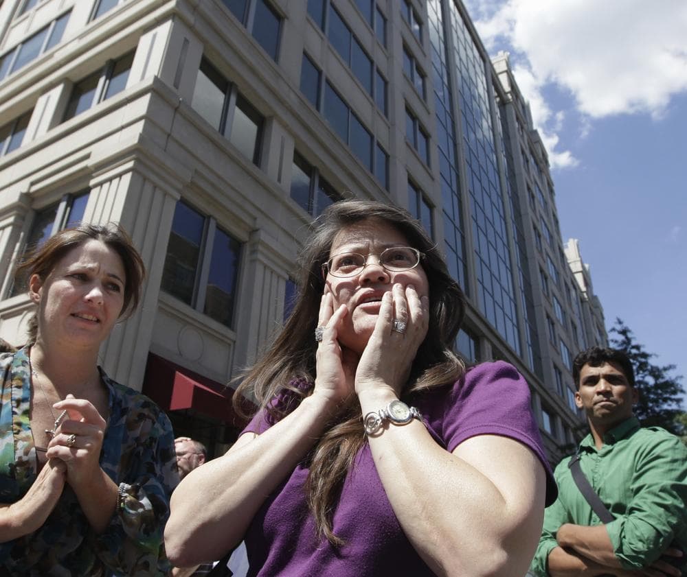 Susy Ward, center, and other office workers gather on the sidewalk in downtown Washington moments after an earthquake shook the nation's capitol. (AP)