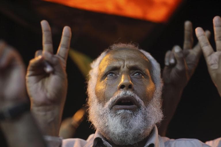 Salem Hasam Ali, 62, a shop owner, cries and flashes v-sign after singing Libya's pre-Gadhafi national anthem in the rebel-held town of Benghazi, Libya, late Tuesday. (AP)