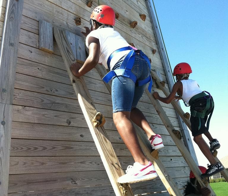 Children climbing the wall at Camp Harbor View (Delores Handy/WBUR)