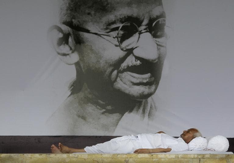 India's anti-corruption activist Anna Hazare rests in front of a giant portrait of Mahatma Gandhi on the ninth  day of his hunger strike, in  New Delhi, India, Wednesday, Aug. 24, 2011.  (AP)