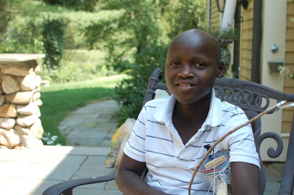 Sibo Tuyishimire, age 13, plays a violin he made during his stay in the U.S. for a bone marrow transplant. He's scheduled to return home to Rwanda later this year. (Jill Ryan/Here &amp; Now)