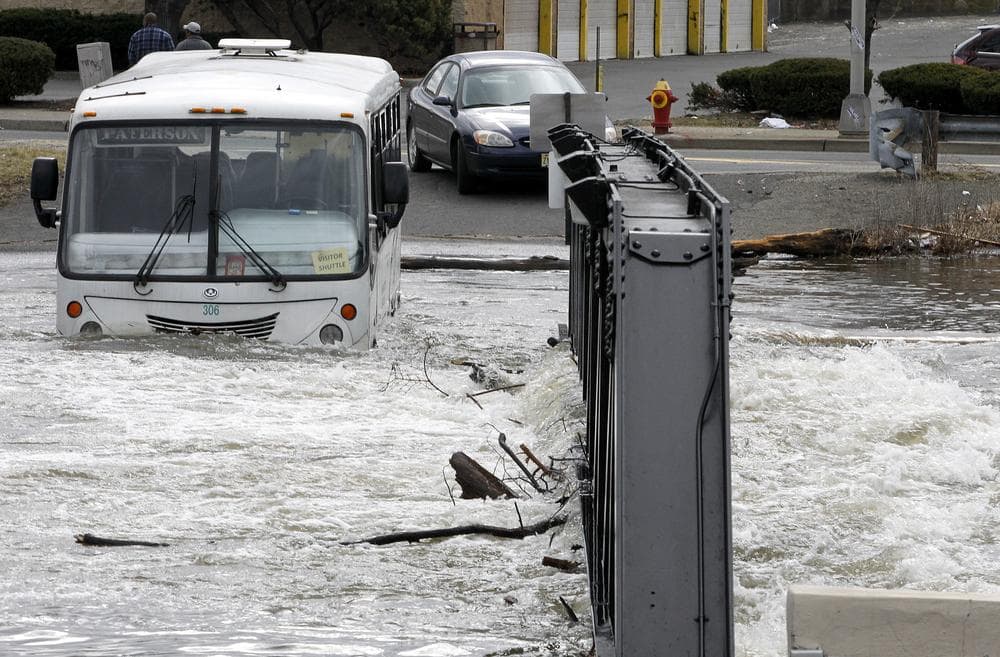 An Express Service bus is seen stuck on a small bridge in downtown Paterson, N.J., where high waters from the Passaic River made the crossing impossible, Sunday. (AP)